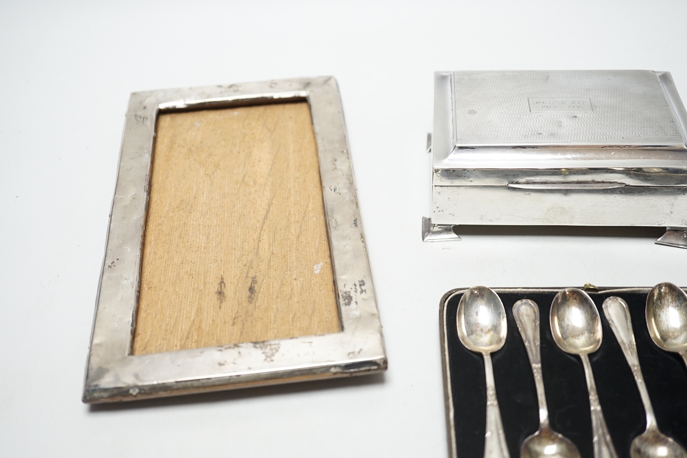 A set of six George VI silver teaspoons, Birmingham, 1939, cased, a silver cigarette box and a silver framed photograph frame.